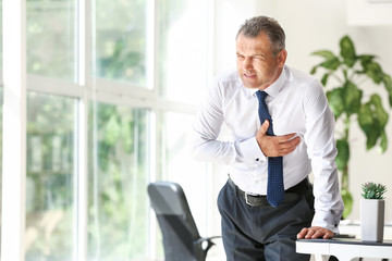 Poster - Mature man suffering from heart attack in office