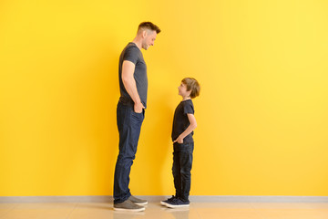 portrait of father and son near color wall