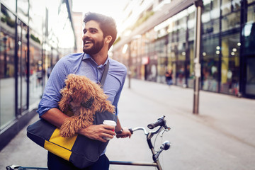 Handsome business man on street drinking coffee with dog