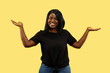 © master1305 - Young african-american woman isolated on yellow studio background, facial expression. Beautiful female half-length portrait. Concept of human emotions, facial expression. Choosing and inviting.