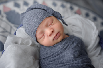 Wall Mural - Newborn baby boy wrapped in gray fabric