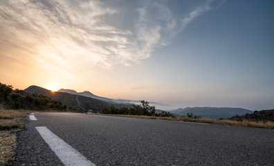 Wall Mural - Empty long road on a sunny summer day at bright sunset