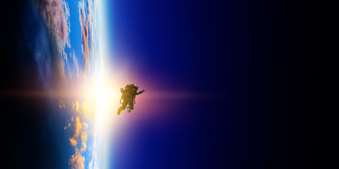 Wall Mural - astronaut in space on planet orbit.