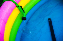Outdoor Colorful Inflatable Pool With Clean Water. Water Fills The Pool Through The Hose