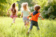 © Andrey - A group of happy children of boys and girls run in the Park on the grass on a Sunny summer day . The concept of ethnic friendship, peace, kindness, childhood