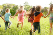 © Andrey - A group of happy children of boys and girls run in the Park on the grass on a Sunny summer day . The concept of ethnic friendship, peace, kindness, childhood