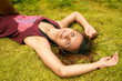 © EverGrump - Young satisfied tanned woman lying on a green moss in the forest. Girl traveler enjoys the fresh air and the surrounding nature. Wearing a swimsuit and a t-shirt