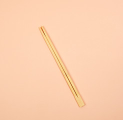 two wooden chopsticks on a beige background