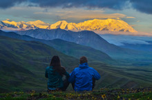 Sunrise View Of Mount Denali - Mt Mckinley Peak With Alpenglow During Golden Hour With Two Persons From Stony Dome Overlook. Denali National Park