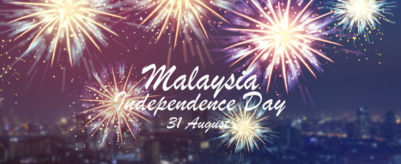 Wall Mural - show group of exploding fireworks bright light colorful and falling fire glitter on blur city buildings panoramic view background for malaysia independence day and s concept