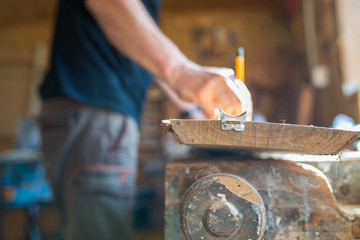 Wall Mural - Carpenter marking oak wood board with  yellow pencil in workshop, focus on the board, shallow depth of field, visible dust.