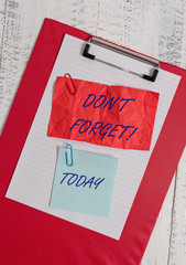 Conceptual hand writing showing Don T Forget. Concept meaning used to remind someone about an important fact or detail Clipboard paper crushed sticky note clip wooden background