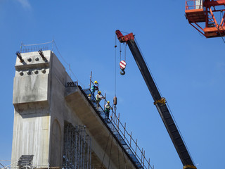 Wall Mural - Construction workers working at height at the construction site. They are requested to wear appropriate safety gear to prevent bad happen to them. 