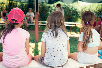Wall Mural - children's meeting. three girlfriend sitting on the meeting in the outdoor summer camp.