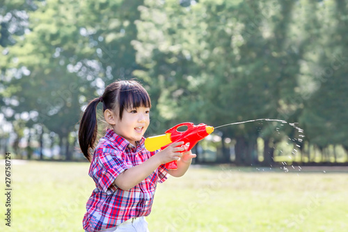 新緑の樹木を背景に水鉄砲で遊ぶ幼い女の子 自由 遊び 子供 幸せ 元気イメージ Adobe Stock でこのストック画像を購入して 類似の画像をさらに検索 Adobe Stock