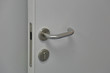 Minimalistic design of the door handle in metallic color on a gray background
