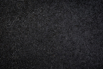 High resolution full frame textured dark background of wet, black asphalt, viewed from above.