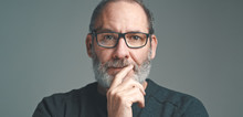 Portrait Of A Bearded Mature Adult Casual Businessman With Glasses Looking Into Camera