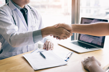 Dentist agreed with the patient by holding shaking hands with confidence.