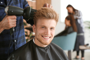 Professional hairdresser working with client in beauty salon