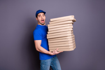 Wall Mural - Close up side profile photo amazing specialist he him his delivery boy hold arms many heavy parcel boxes unexpected big shipment move slowly wear blue t-shirt cap jeans denim isolated grey background