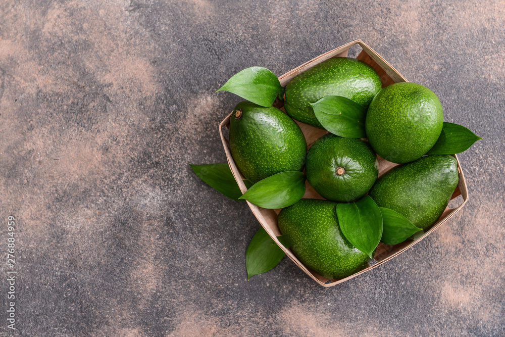 Box with fresh ripe avocados on grey background