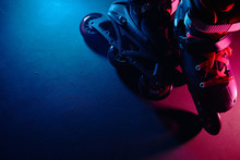 Close Up View Of Roller Skates Inline Skate Or Rollerblading On Dark Grunge Background In Neon Blue Magenta Pink Light
