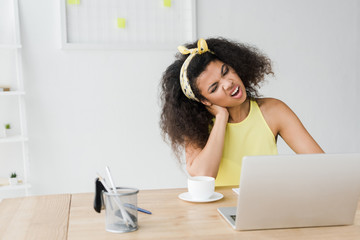 Wall Mural - curly brunette african american woman having neck pain