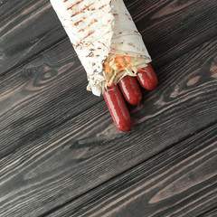 Wall Mural - homemade sausages in pita bread on wooden background