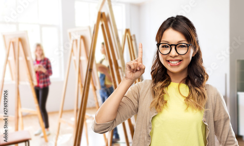 Foto art school and creativity concept - happy asian woman in glasses or student poin