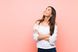 © luismolinero - Young woman over isolated pink background looking up while smiling