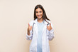 © luismolinero - Young doctor woman over isolated background giving a thumbs up gesture