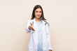 © luismolinero - Young doctor woman over isolated background handshaking after good deal