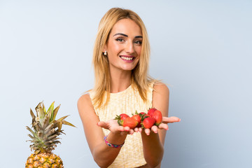 Happy  Young blonde woman with lots of fruits