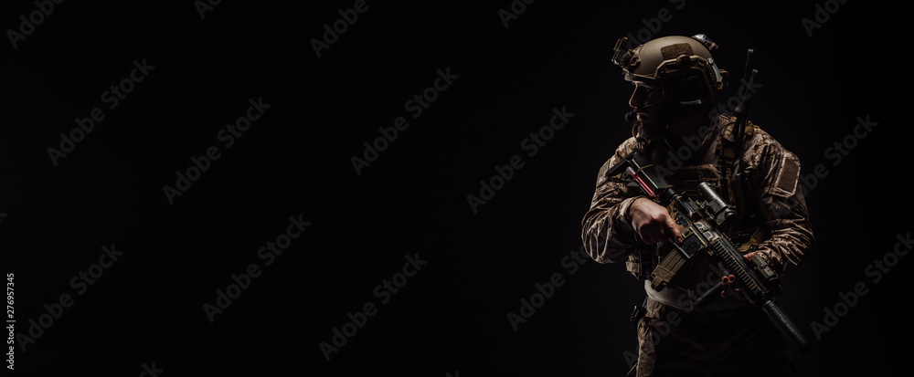 Special forces United States soldier or private military contractor holding rifle. Image on a black background. - obrazy, fototapety, plakaty 