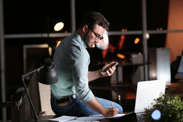 Young man working in office at night