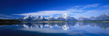 Fototapeta Do przedpokoju - Panoramic View of Beautiful White Winter Wonderland Scenery in the Alps with Snowy Mountains Summits Reflecting in Crystal Clear Mountain Lake on a Cold Sunny Day with Blue Sky and Clouds.