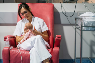 Wall Mural - Female doctor examining newborn baby after lunch. Night shift