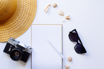 Flat lay design of travel concept with camera, notebook, hat, shells