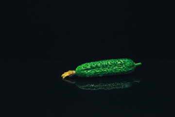 Aufkleber - Close up Beautiful  fresh cucumbers and yellow flower on a black glass table dark background.