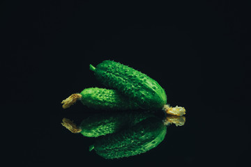 Aufkleber - Beautiful  fresh cucumbers and yellow flower on a black glass table dark background.