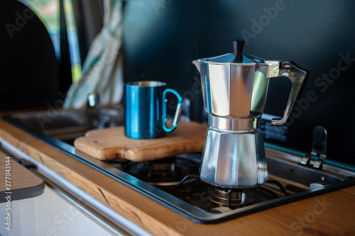 Fotomural Aqua Bialetti stovetop coffee maker and mug, on a van gas cooker