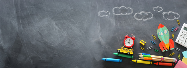 education. Back to school concept. rocket cut from paper and painted over blackboard background. top view, flat lay. banner