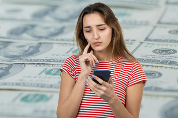 Young beautiful woman using mobile phone studio on white color background. Looking attentively at screen of cellphone, browsing web pages. 