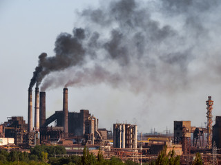 Air pollutants emissions. Toxic smoke of air pollutants, released into the atmosphere by chimney smoking stack at by-product coke plant in metallurgy industry, pollutes the environment.