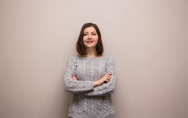 Wall Mural - Portrait of young brunette girl in grey sweater 