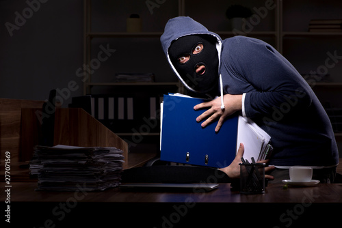 Cuadros en Lienzo Male thief in balaclava in the office night time