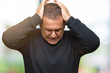 © Krakenimages.com - Middle age bussines arab man wearing glasses over isolated background suffering from headache desperate and stressed because pain and migraine. Hands on head.