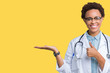 © Krakenimages.com - Young african american doctor woman wearing medical coat over isolated background Showing palm hand and doing ok gesture with thumbs up, smiling happy and cheerful
