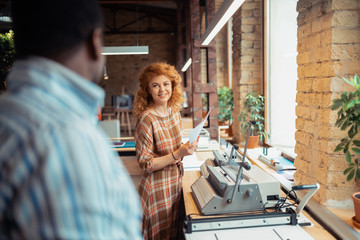 Canvas Print - Woman smiling while talking to dark-skinned colleague